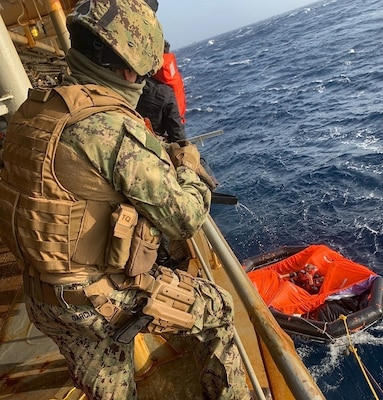 Master-at-Arms 2nd Class Michael Garcia, assigned to Embarked Security Intelligence Team 11, deployed with Commander, Task Force (CTF) 56, aboard the Military Sealift Command fleet replenishment oiler USNS Patuxent (T-AO 201), relays information on a radio during rescue operations for the crew members of a motor vessel Falcon Line, which sank in the Gulf of Aden, June 8.