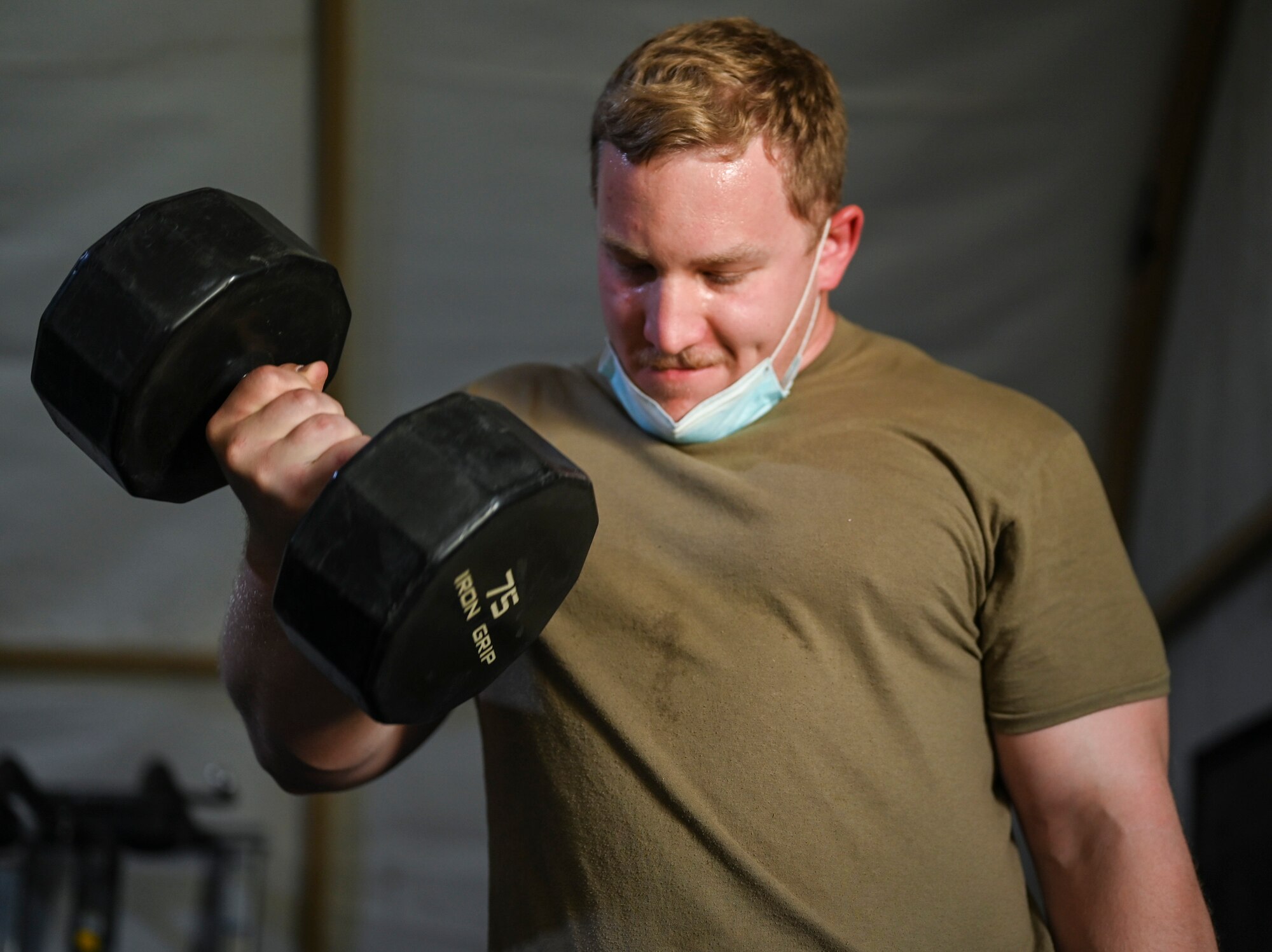 A photo of an Airman lifting weights.