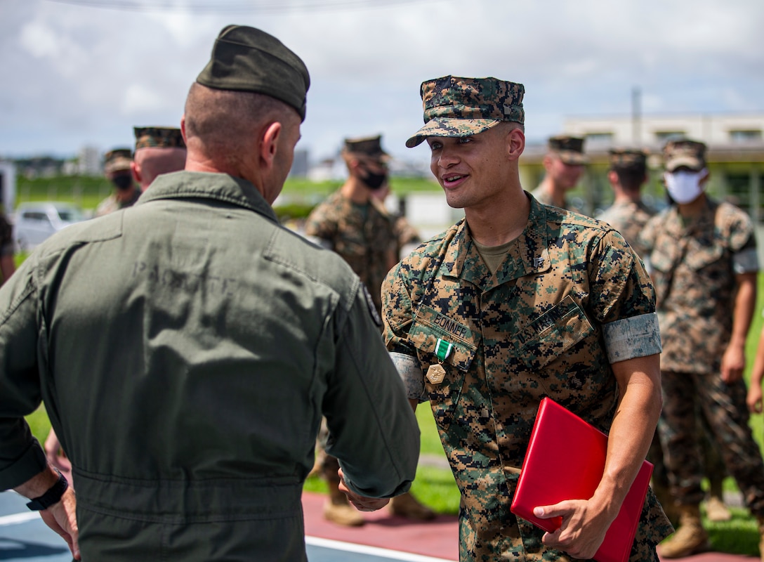 U.S. Marine Corps Cpl. Dominick Bonner, a chemical, biological, radiological, and nuclear defense specialist with the 1st Marine Aircraft Wing, is congratulated by Marines after receiving a Navy and Marine Corps Commendation Medal on Marine Corps Air Station Futenma, Okinawa, Japan, June 8, 2021. Bonner, a native of Parkville, Maryland, was enjoying breakfast at a restaurant to celebrate his wife’s birthday when he was made aware of a restaurant employee who required medical attention. After entering the kitchen area and locating the man, lying motionless without a pulse, Bonner laid the man on his back and began chest compressions, taking over for a fatigued employee. Bonner continued to provide lifesaving aid for over ten minutes, sustaining the man’s life, until relieved by Japanese paramedics who evacuated the man to a local medical facility.