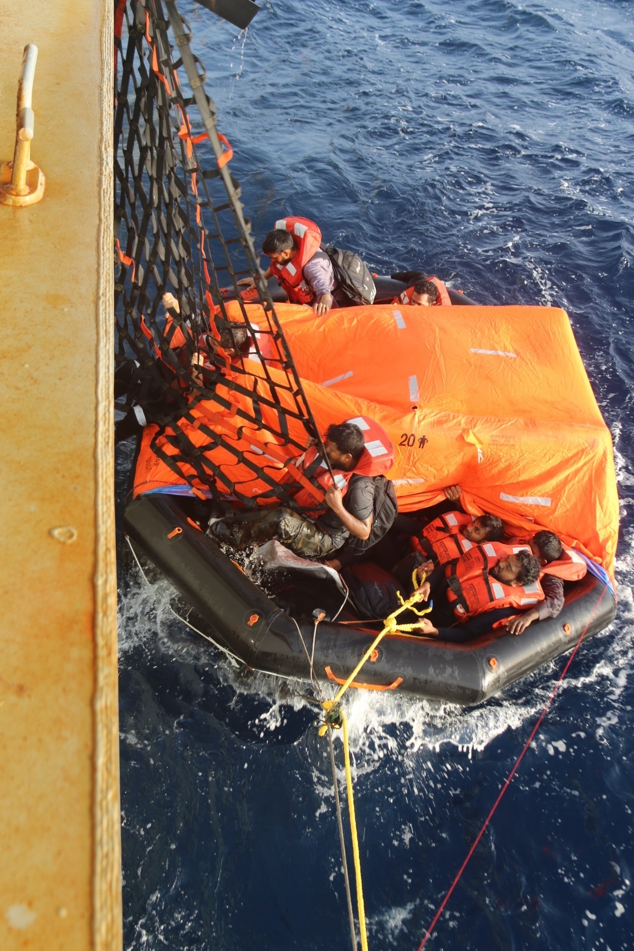 Crew members of a motor vessel Falcon Line climb aboard the Military Sealift Command (MSC) fleet replenishment oiler USNS Patuxent (T-AO 201) during rescue operations in the Gulf of Aden, June 8.