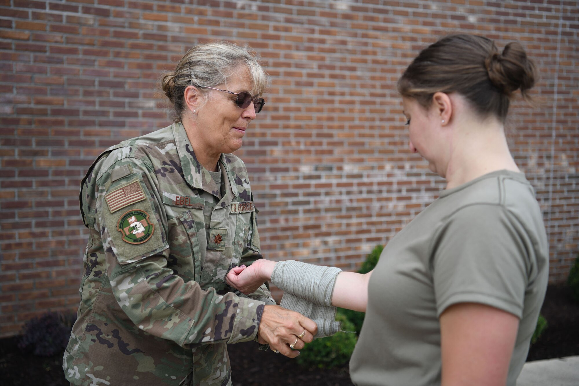 Maj. Kimberly Ebel, 445th Aeromedical Staging Squadron and East Central Georgia Medical Innovative Readiness Training mission officer in charge, applies a dressing onto a fellow Airman’s arm during Tactical Combat Casualty Care training at Burke County High School here June 8, 2021