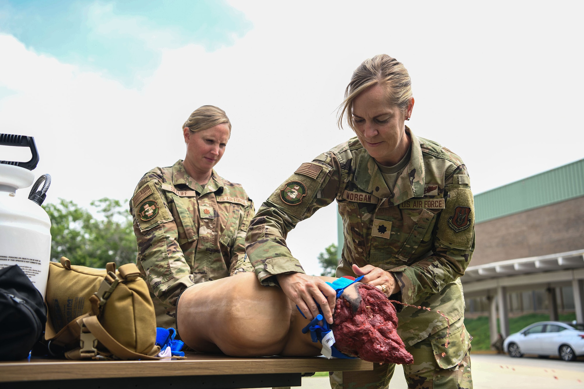 Maj. Michelle Setliff, 445th Aeromedical Staging Squadron, assists Lt. Col. Amelia Morgan, 445th Aerospace Medicine Squadron, on the application of a tourniquet on a training dummy during Tactical Combat Casualty Care (TCCC) training at Burke County High School here June 8, 2021