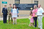 A family stands in front of a sign.