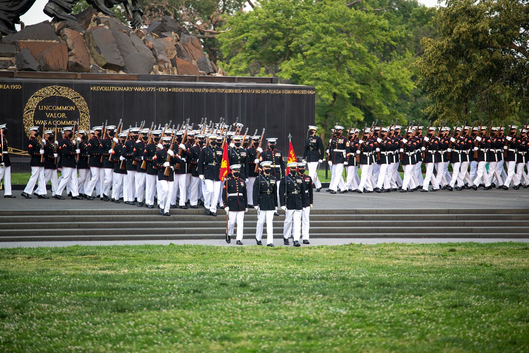 Marines with Marine Barracks Washington march into formation during a Tuesday Sunset Parade at the Marine Corps War Memorial, Arlington, Va., June 8, 2021. The hosting official for the evening was Mr. Robert D. Hogue, counsel for the Commandant of the Marine Corps, and The Honorable Kirsten E. Gillibrand, U.S. Senator for New York, was the guest of honor. (U.S. Marine Corps photo by Lance Cpl. Mark Morales)