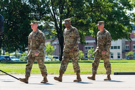 three men walking wearing army uniforms.