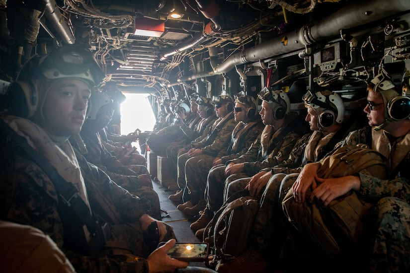 U.S. Marines, Australian service members sit aboard a V-22 Osprey.