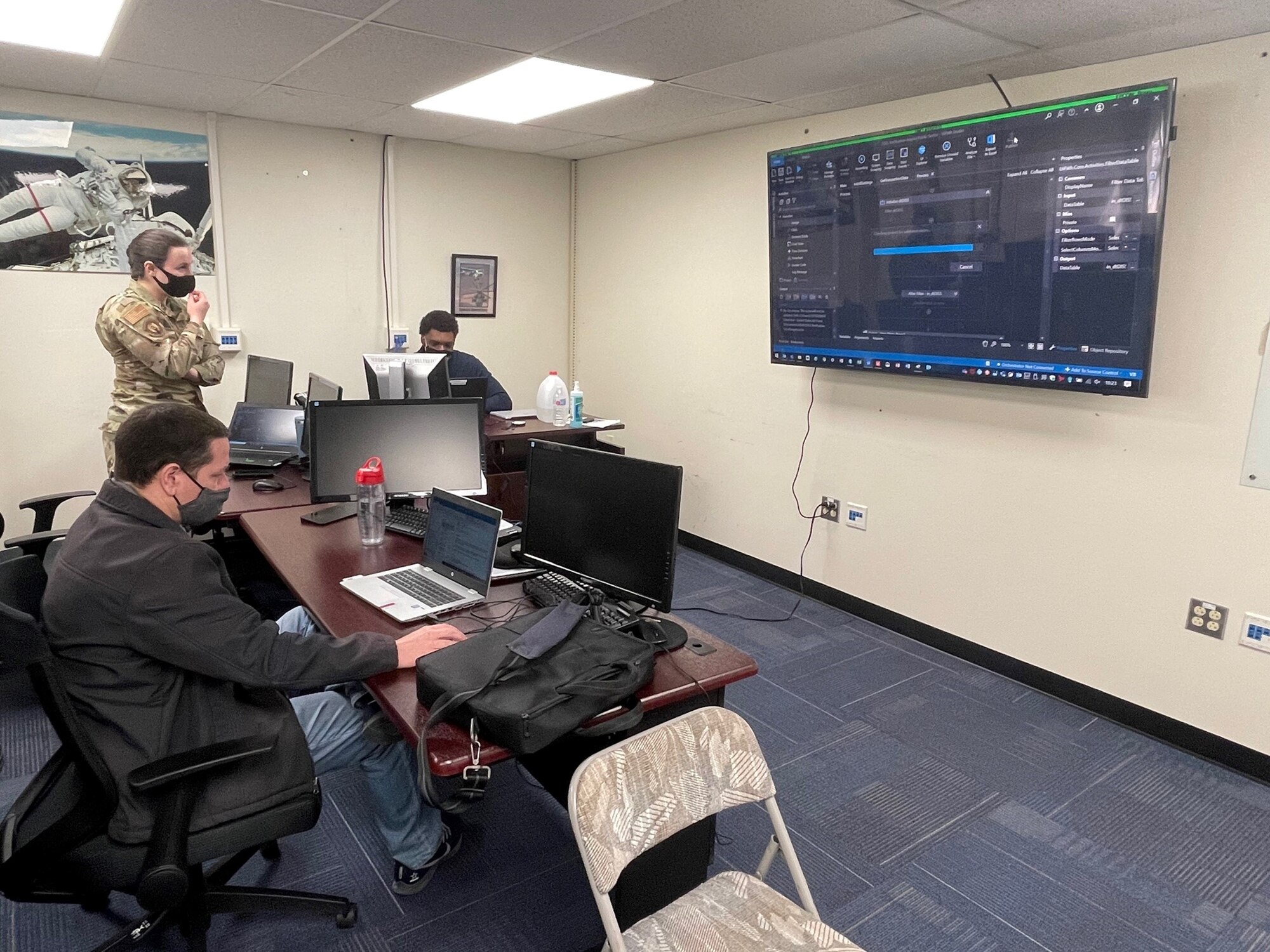 Jamie Rychecky and 2nd Lt. Arianna Lemieux from the 21st Intelligence Squadron work with Chaz Jenkins (right) from Invoke Inc work on a security automation.
