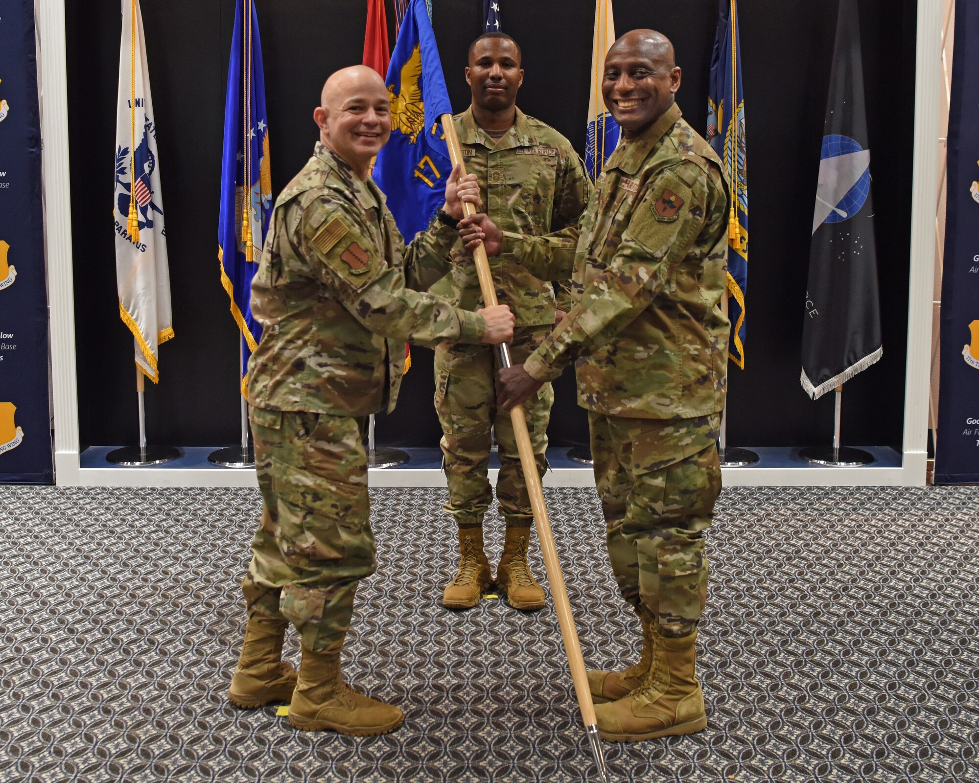 U.S. Air Force Col. Andres Nazario, 17th Training Wing commander, passes the 17th Medical Group guidon to Col. Derek Larbie, 17th MDG incoming commander, during the change of command ceremony at the Event Center on Goodfellow Air Force Base, Texas, June 8, 2021. Larbie was the 59th Medical Wing Staff Agency commander at Joint Base San Antonio, Texas, before his current assignment at Goodfellow. (U.S. Air Force photo by Senior Airman Abbey Rieves)