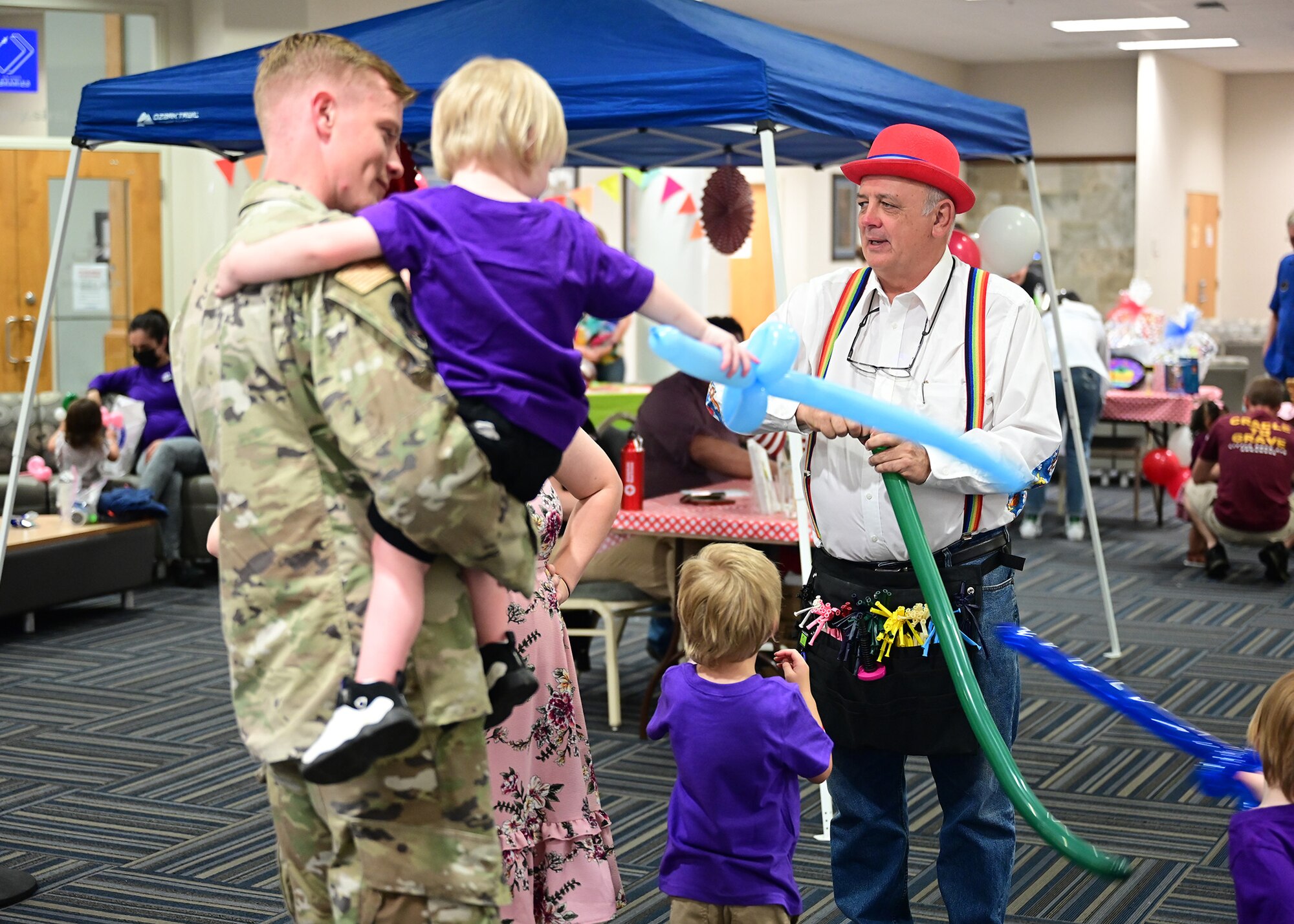 Children watch as a man makes a balloon animal.