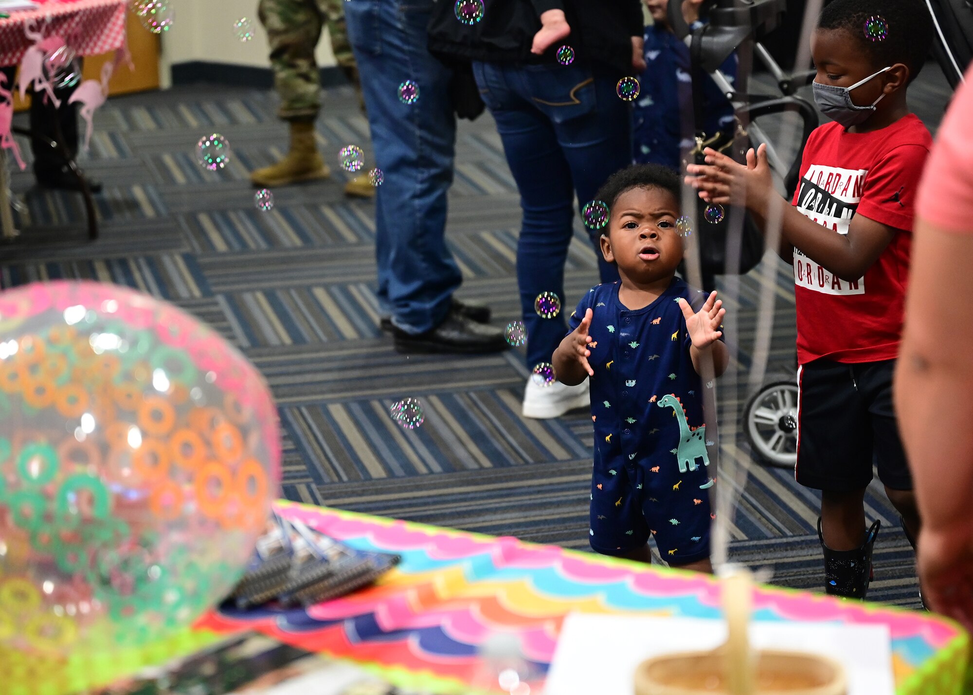 A kid plays with bubbles floating in the air.
