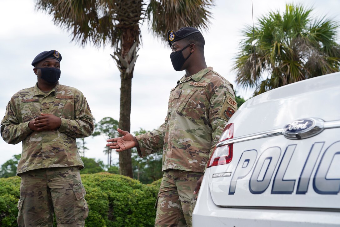 U.S. Air Force Senior Airman Leonard Brown, 81st Security Forces Squadron NCOIC of police services, talks to Airman 1st Class Grady Adams, 81 SFS patrolman, outside the security forces building at Keesler Air Force Base, Mississippi, June 7, 2021. The 81st SFS is responsible for making sure the base populace is safe at all times. (U.S. Air Force photo by Senior Airman Spencer Tobler)