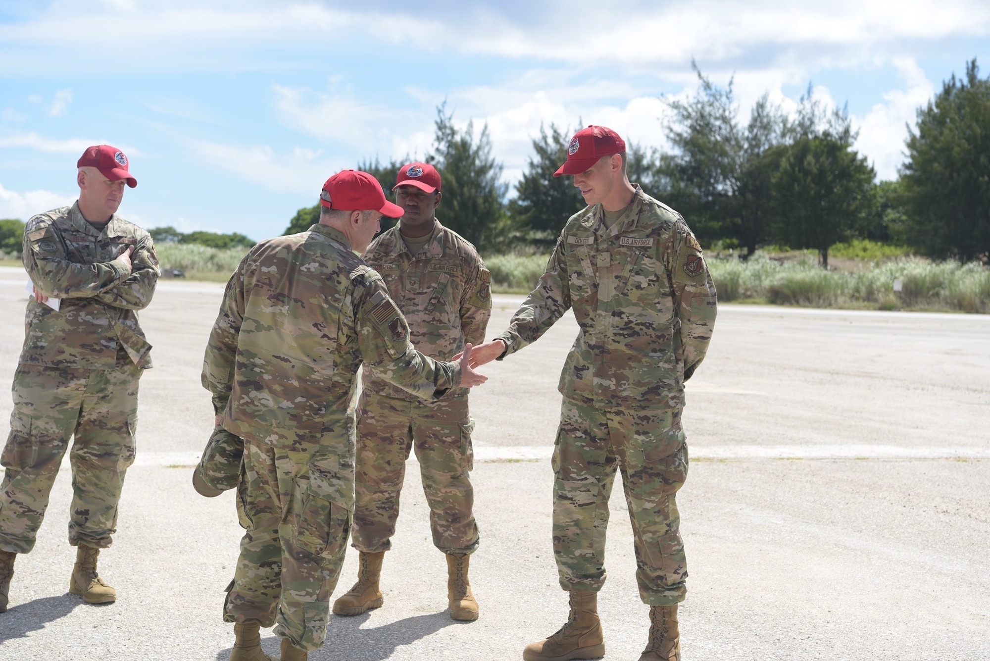 U.S. Air Force Chief Master Sgt. Kristopher Berg, 11th Air Force Command Chief, presents a coin to Airman 1st Class Daniel Dolgos, assigned to the 554th RED HORSE Squadron, June 7, 2021, at Andersen Air Force Base, Guam.