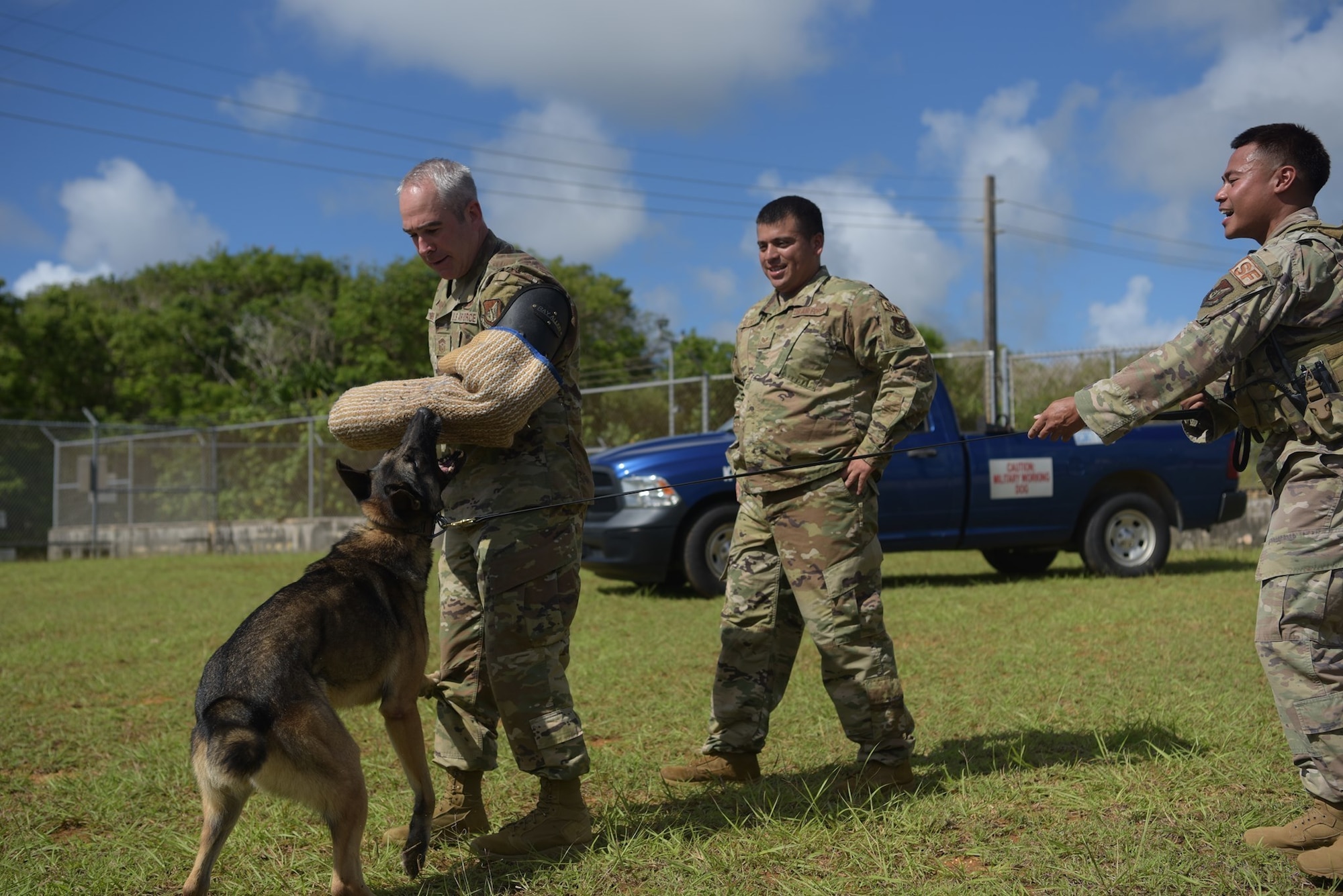 U.S. Air Force Chief Master Sgt. Kristopher Berg, 11th Air Force Command Chief, wears a protective arm sleeve and is bitten by a military working dog from the 36th Security Forces Squadron as part of a demonstration, June 8, 2021, at Andersen Air Force Base, Guam.