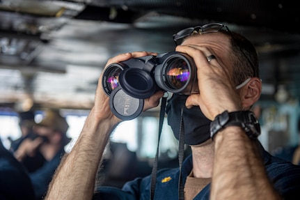 Lt. Cmdr. Bill Zincicolalapin, from Nutley, New Jersey, uses binoculars to look for surface contacts on the bridge of the Nimitz-class aircraft carrier USS Harry S. Truman (CVN 75) during Tailored Ship's Training Availability (TSTA) and Final Evaluation Problem (FEP).