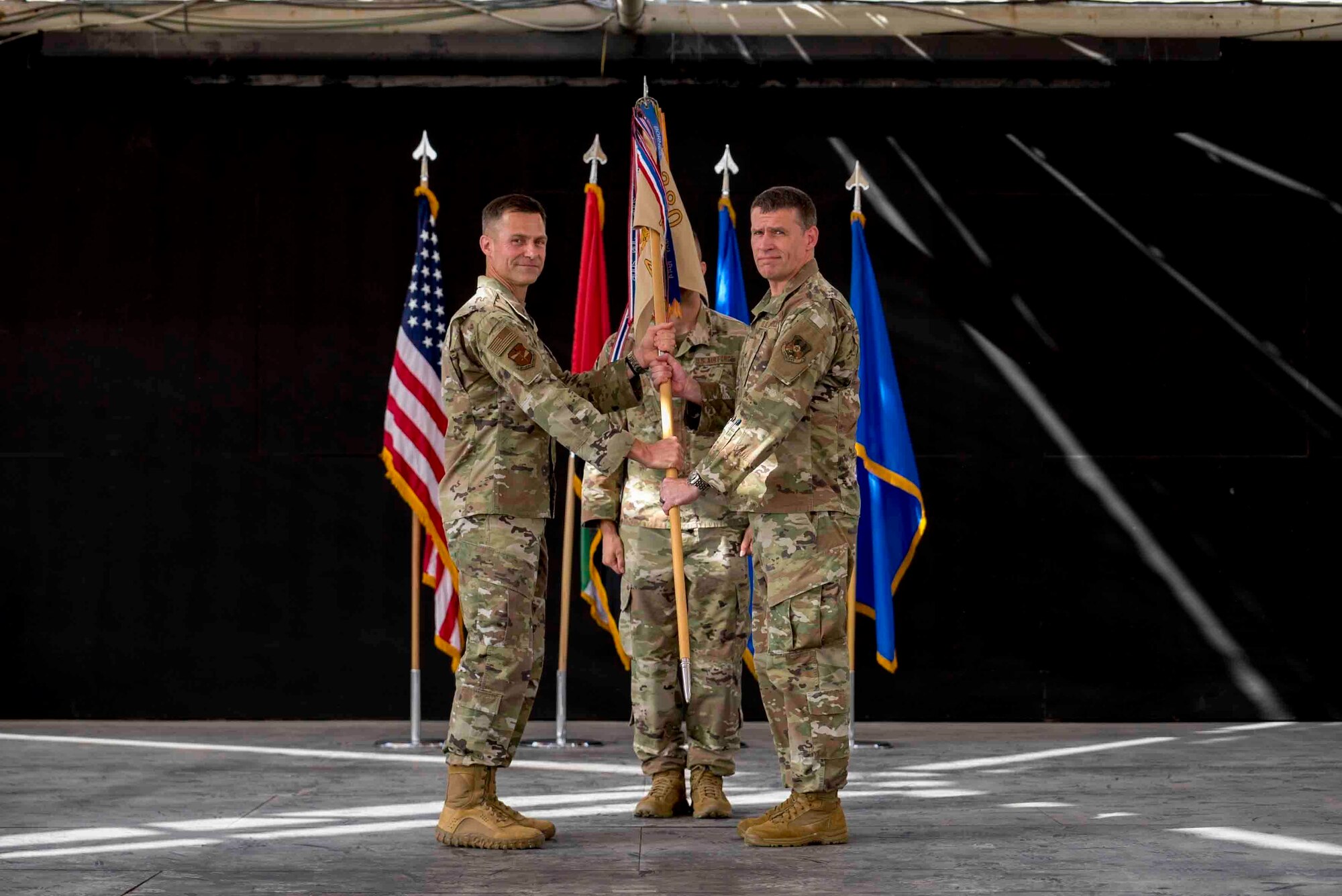 U.S. Air Force Brig. Gen. Larry Broadwell, outgoing commander, passes command of the 380th Air Expeditionary Wing to Brig. Gen. Andrew Clark, incoming commander, during a change of command ceremony at Al Dhafra Air Base, United Arab Emirates, June 8, 2021. The change of command ceremony is a military tradition that represents a formal transfer of authority and responsibility for a unit from one commanding officer to another.