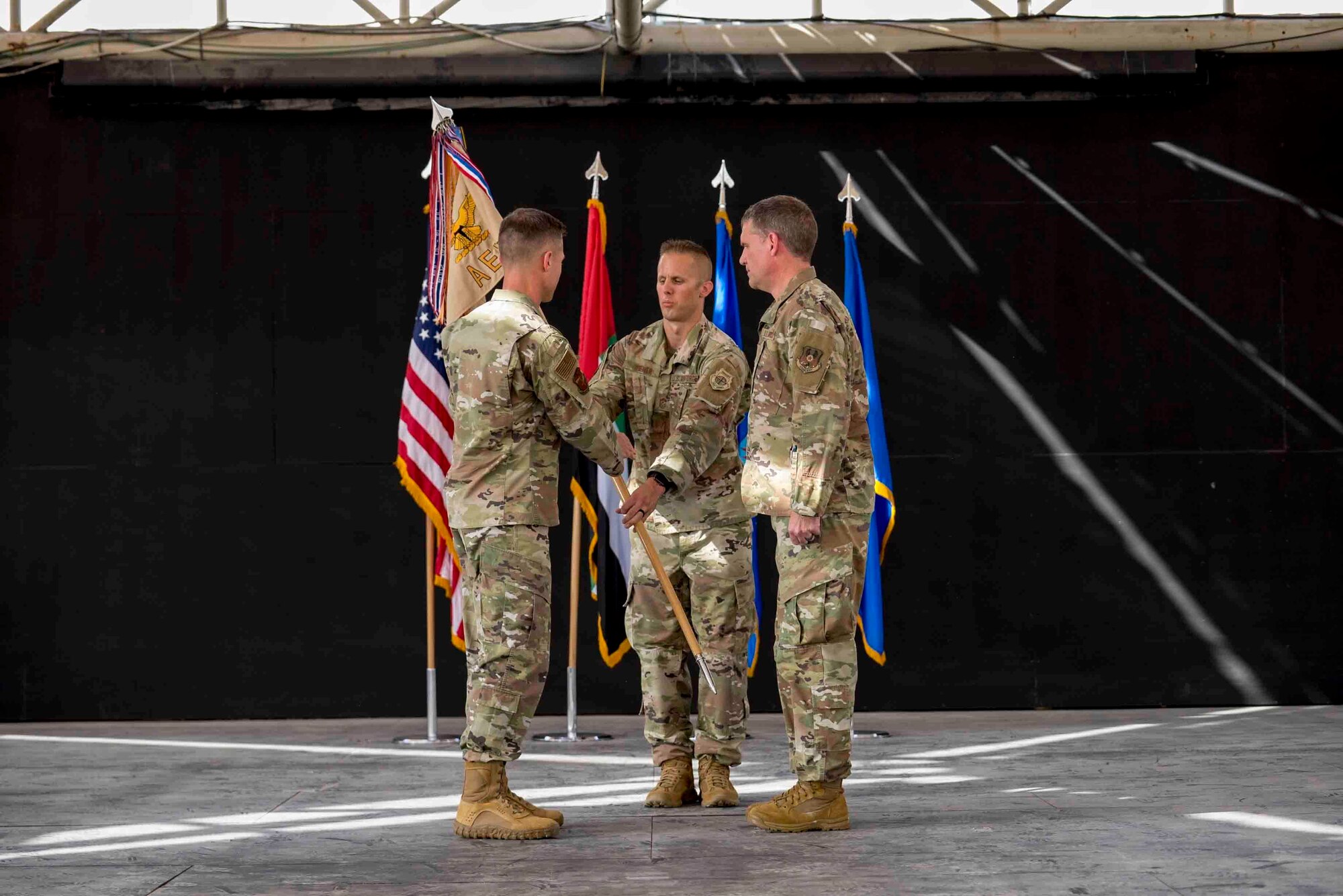 U.S. Air Force Brig. Gen. Larry Broadwell, outgoing commander, passes command of the 380th Air Expeditionary Wing to Brig. Gen. Andrew Clark, incoming commander, during a change of command ceremony at Al Dhafra Air Base, United Arab Emirates, June 8, 2021. The change of command ceremony is a military tradition that represents a formal transfer of authority and responsibility for a unit from one commanding officer to another.