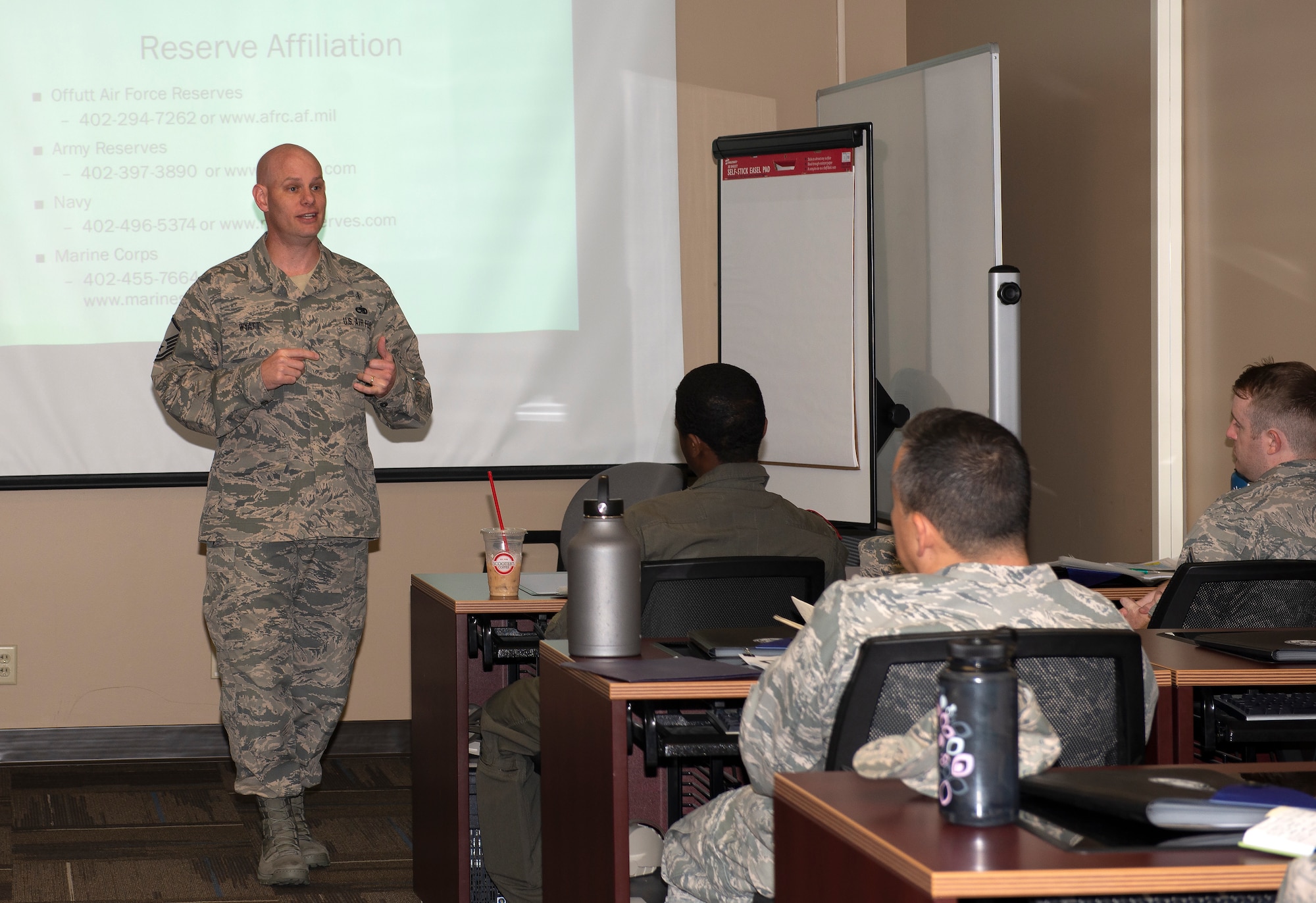 Airmen in front of a classroom speaking to Airmen seated at each desk