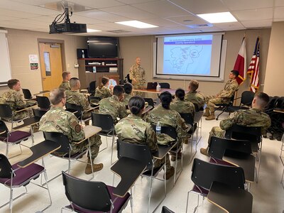 A U.S. Army warrant officer briefs cadets from the U.S. Air Force Academy in a classroom.