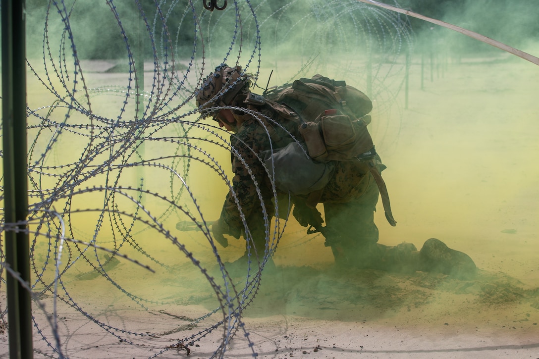 U.S. Marine Corps Pfc. Austin Pierce, a combat engineer with 2nd Combat Engineer Battalion, 2nd Marine Division, mechanically breaches a concertina wire obstacle during a demolition range as part of a Marine Corps Combat Readiness Evaluation on Camp Lejeune, N.C., June 7, 2021. The purpose of the range was to build core proficiency, improve combat readiness and to better prepare for combat scenarios before deployment.