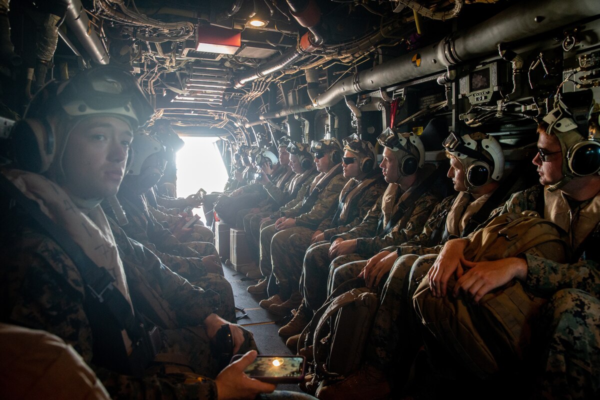 U.S. Marines, Australian service members sit aboard a V-22 Osprey.