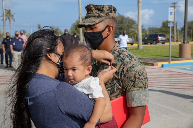 Mia Ooka, Left, pins the rank of Sergeant on her husband, Sgt. Nicohlas Benjamin D. Ookam Right, for the first time during a promotion ceremony held on Marine Corps Base (MCB) Camp Blaz on May 4, 2021.