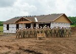 Alaska Air National Guardsmen with the 176th Civil Engineer Squadron stand alongside Brig. Gen. Anthony Stratton, 176th Wing commander, as they near the end of their participation in the Cherokee Veterans Housing Initiative in Tahlequah, Oklahoma, May 27, 2021. The initiative is a collaboration between the Department of Defense’s Innovative Readiness Training program and the Cherokee Nation to build new single-family homes and supporting infrastructure for eligible Cherokee Nation veterans and their families.