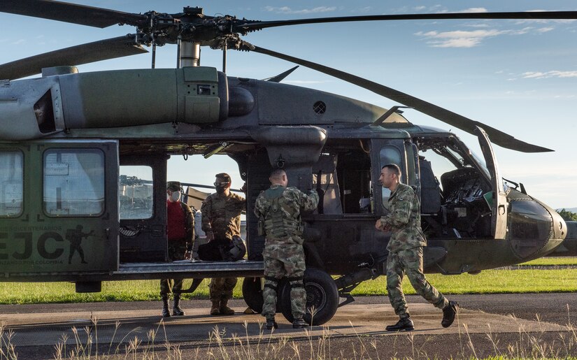 U.S. Army Chief Warrant Officer 3 Mauricio Garcia, left inside Black Hawk door, and his Colombian safety officer counterpart, Capt. Cristian Castiblanco, inspect a refueling operation at Tolemaida Army Base in Colombia.