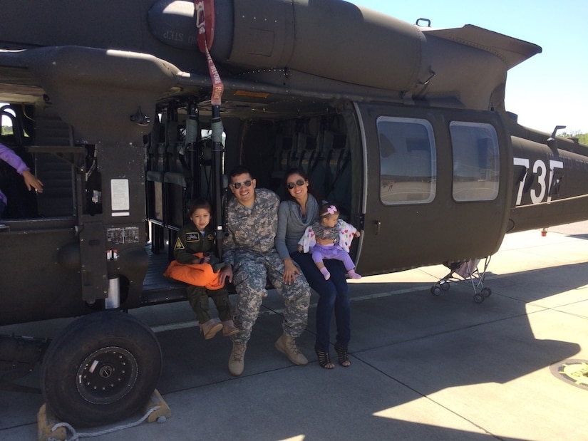U.S. Army Chief Warrant Officer Mauricio Garcia, a freshly minted UH-60M Black Hawk pilot, poses with his family during Family Day at Lowe Army Airfield, Fort Rucker, Alabama. (Courtesy photo)