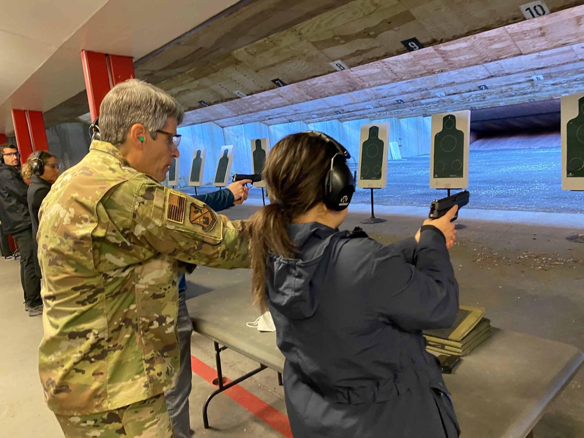 An Air Force Office of Special Investigations Region 5 agent instructs a government civilian, assigned to the U.S. Air Forces in Europe and Air Forces Africa headquarters, in target practice at the firing range on Ramstein Air Base, Germany, May 14, 2021.