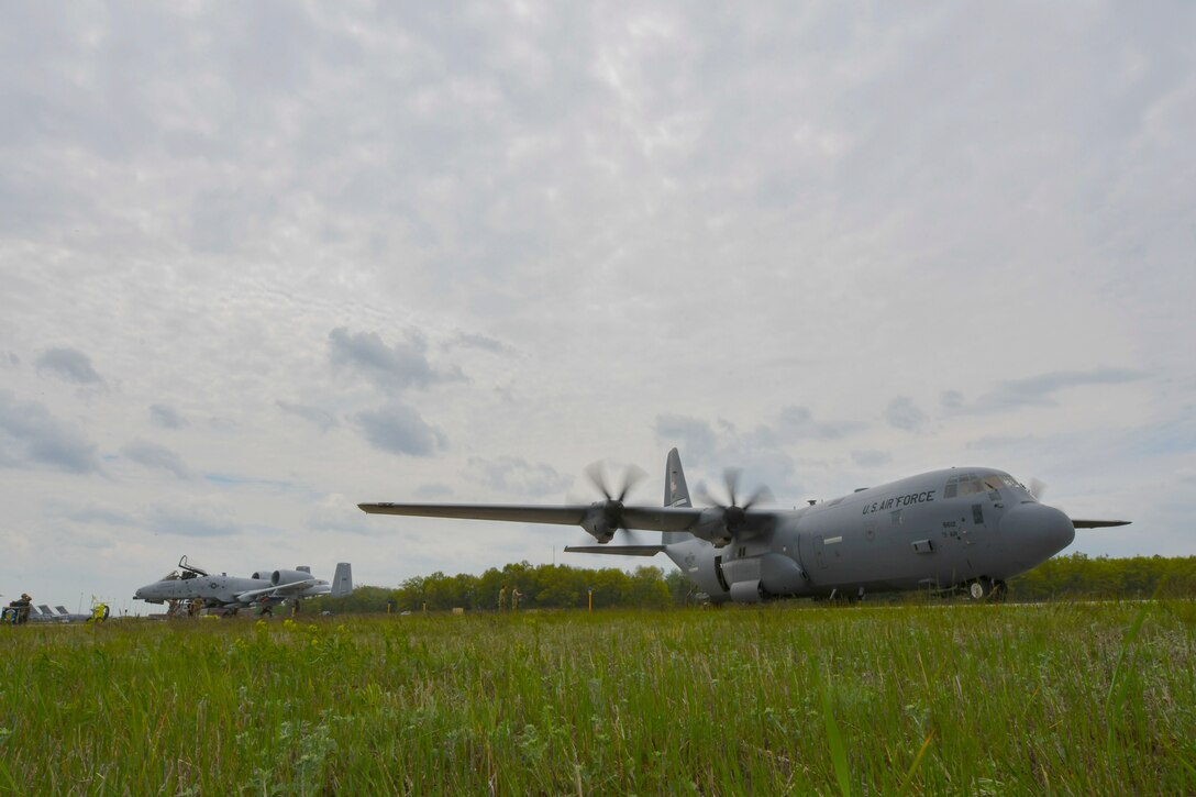 A U.S. Air Force A-10 Thunderbolt II sits next to a U. S. Air Force C-130J Super Hercules