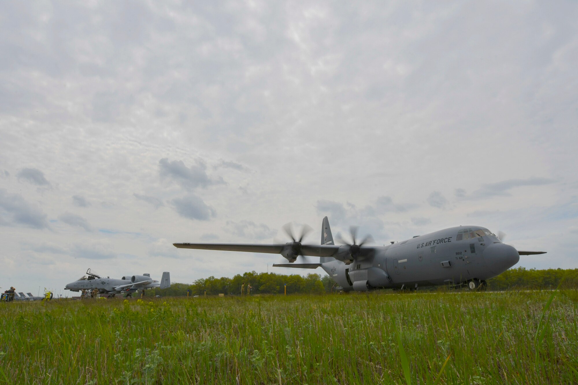 A U.S. Air Force A-10 Thunderbolt II sits next to a U. S. Air Force C-130J Super Hercules