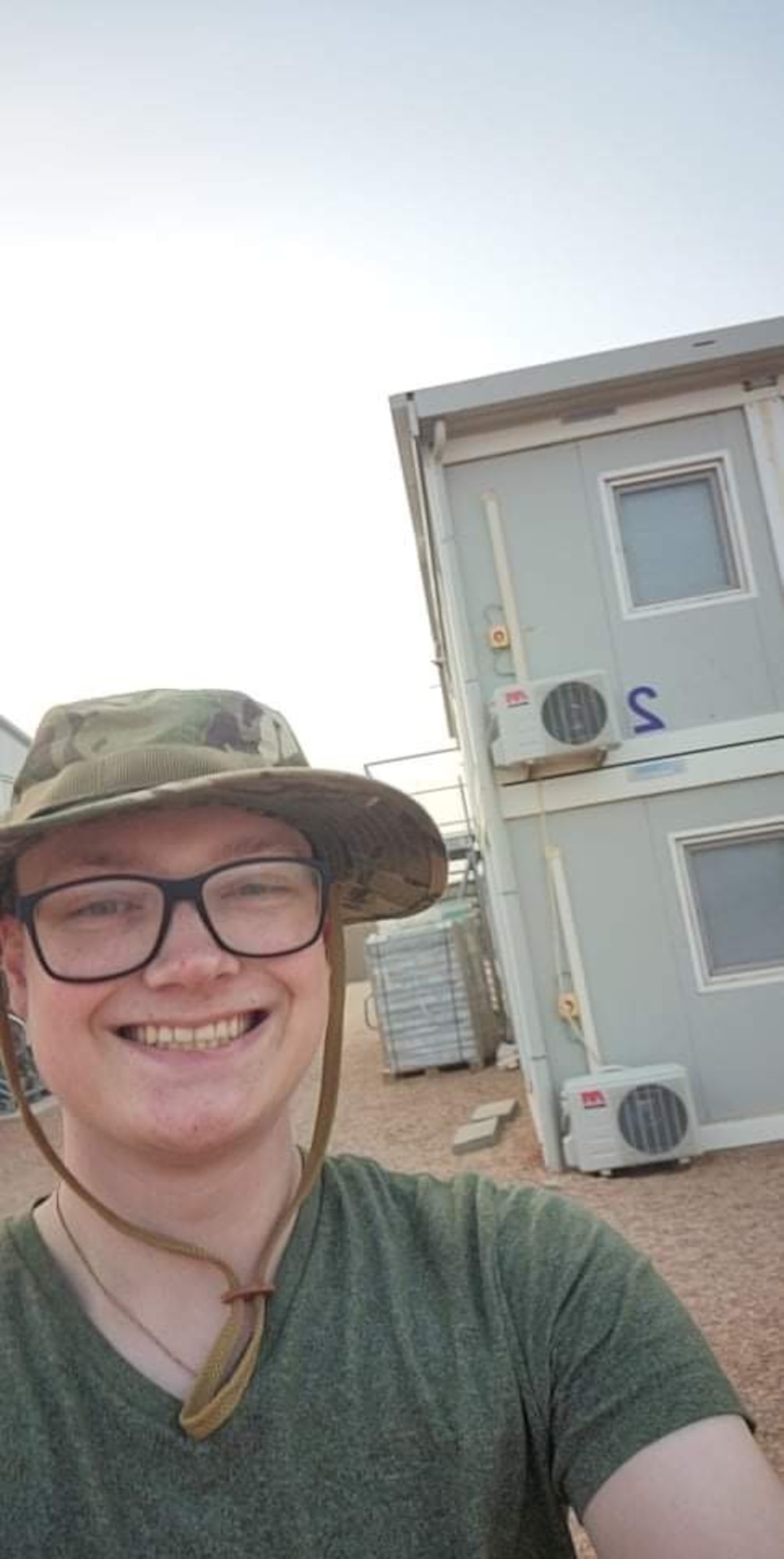 Senior Airman Caleb S. Kimmell smiles outside of his containerized living unit for his first deployment selfie. Kimmell arrived in Africa for his first deployment as a public affairs journeyman for the 435th Air Expeditionary Wing. (U.S. Air Force photo by Senior Airman Caleb S. Kimmell)