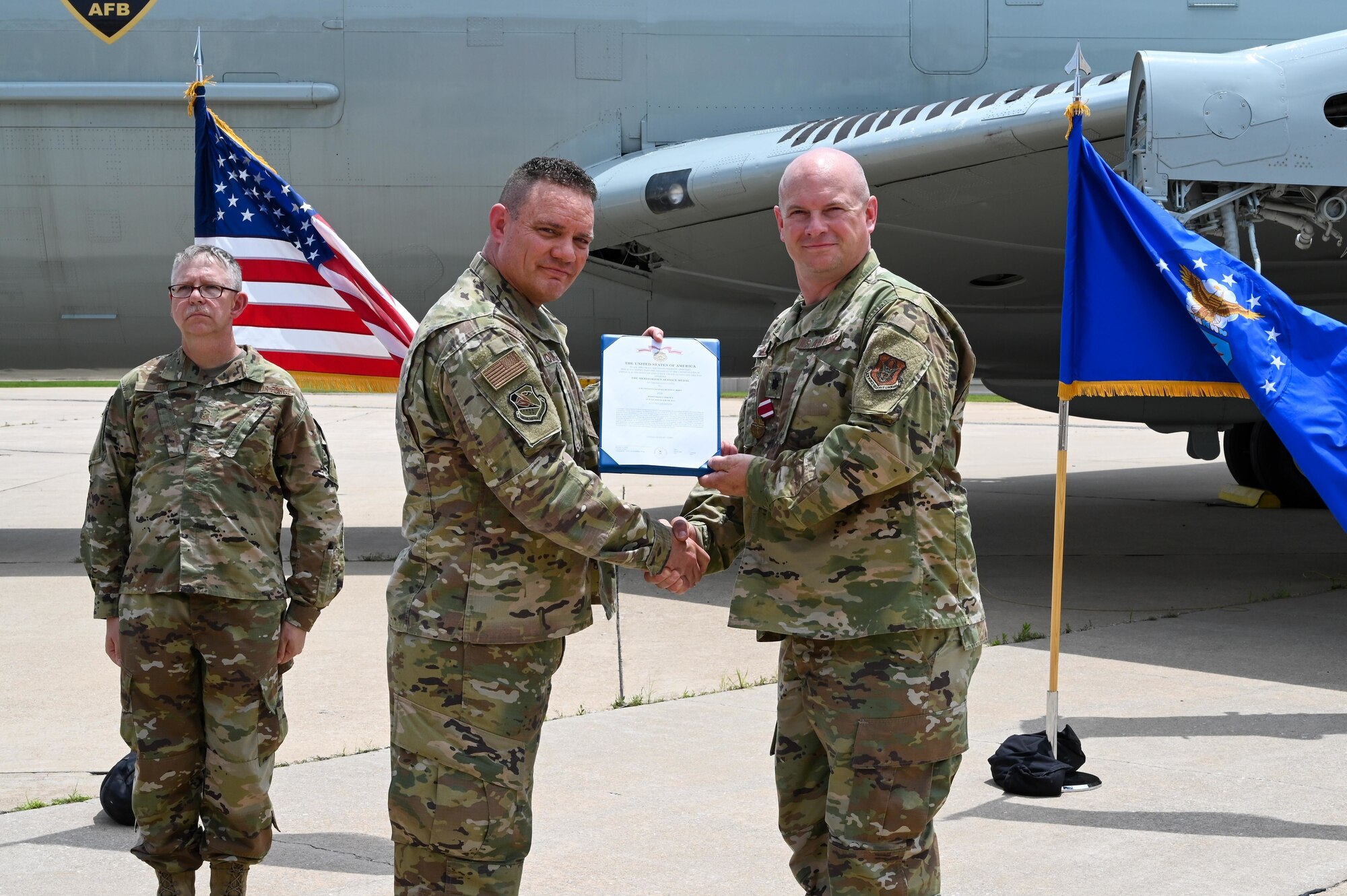Lt. Col. Stan Young, 507th Mission Support Group commander, presents Lt. Col. Dustin Born, 507th Civil Engineer Squadron former commander, a meritorious service medal during an outdoor change of command ceremony on the flightline June 6, 2021, at Tinker Air Force Base, Oklahoma. (U.S. Air Force photo by Senior Airman Mary Begy)