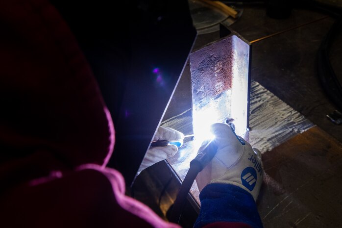 NNSY's Welding Shop (Shop 26) Work Leader Todd Scott works on a mock up (SSN 752). 
RIGHT: Shop 26 Work Leader Jeffrey Hamlin welds a carbon steel foundation.