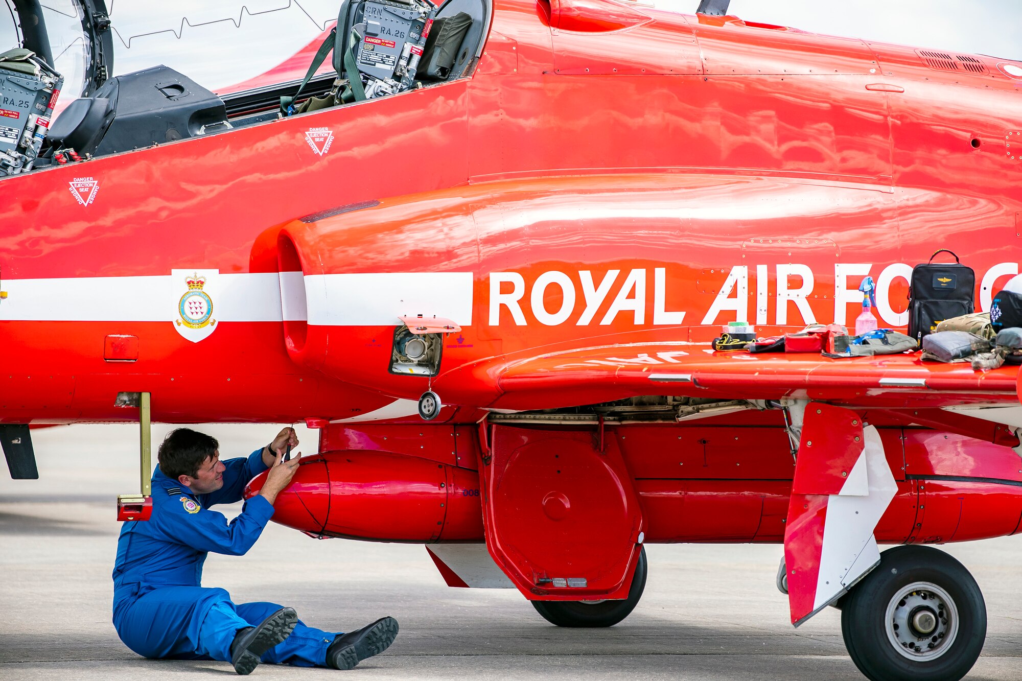 Flight Lieutenant Joe Fallon, Red Arrows Junior Engineering officer, performs maintenance on a Hawk T1 aircraft at RAF Fairford, England, June 4, 2021. The Red Arrows landed at Fairford to refuel in preparation for the Midlands Air Festival. (U.S. Air Force photo by Senior Airman Eugene Oliver)