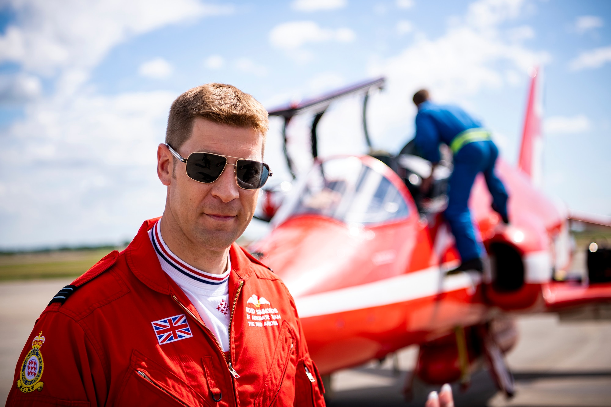 Flight Lieutenant David Simmonds, Royal Air Force aerobatic team pilot, known as the Red Arrows, poses for a photo on the runway at RAF Fairford, England, June 4, 2021. The Red Arrows landed at Fairford to refuel in preparation for the Midlands Air Festival. (U.S. Air Force photo by Senior Airman Eugene Oliver)