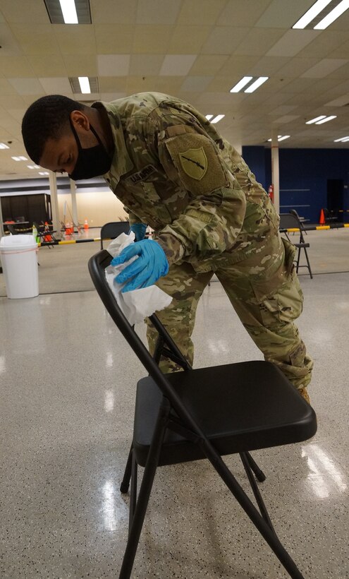 Kentucky Army National Guard Spc. Paulo Salazar with the 101st Main Command Post Operational Detachment, 75th Troop Command, coordinates with a civilian staff member from Med Center Health during the COVID-19 vaccine rollout in Bowling Green, Ky., March 6, 2021. Soldiers from across Kentucky are assisting with vaccine rollouts in Bowling Green, Lexington, and Louisville. (U.S. Army National Guard photo by Staff Sgt. Paul Glover)