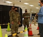 Kentucky Army National Guard Spc. Paulo Salazar with the 101st Main Command Post Operational Detachment, 75th Troop Command, coordinates with a civilian staff member from Med Center Health during the COVID-19 vaccine rollout in Bowling Green, Ky., March 6, 2021. Soldiers from across Kentucky are assisting with vaccine rollouts in Bowling Green, Lexington, and Louisville. (U.S. Army National Guard photo by Staff Sgt. Paul Glover)