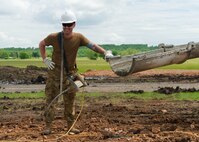 Senior Airman Ryan Pickett, with the 176th Wing’s Civil Engineer Squadron Fire and Emergency Services Flight, smiles with excitement as he finishes pouring 18 cubic yards of concrete on home site number six while participating in the Cherokee Veterans Housing Initiative in Tahlequah, Oklahoma, May 24, 2021. The initiative is a collaboration between the Department of Defense’s Innovative Readiness Training program and the Cherokee Nation that constructs new single-family homes and supporting infrastructure for eligible Cherokee Nation veterans and their families. (U.S. Air Guard photo by Staff Sgt. Clay Cook)