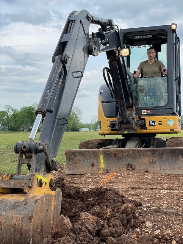 Tech. Sgt. Katie Cramer, with the 176th Wing’s Civil Engineer Squadron Heavy Equipment Shop, digs a trench with a mini-excavator in preparation for pouring concrete footers on home site six while participating in the Cherokee Veterans Housing Initiative in Tahlequah, Oklahoma, May 26, 2021. The initiative is a collaboration between the Department of Defense’s Innovative Readiness Training program and the Cherokee Nation that constructs new single-family homes and supporting infrastructure for eligible Cherokee Nation veterans and their families.  (U.S. Air Guard photo by Senior Master Sgt. Michael Keegan)