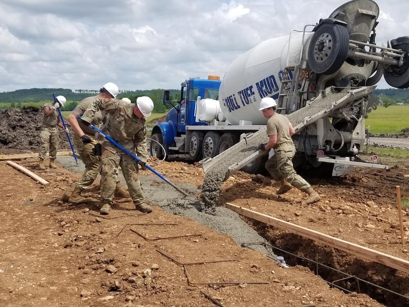 Tech. Sgt. Katie Cramer, right, with the 176th Wing’s Civil Engineer Squadron, leads the crew while placing and finishing 18 cubic yards of concrete for the footers on home site number six during the Cherokee Veterans Housing Initiative in Tahlequah, Oklahoma, May 24, 2021. The initiative is a collaboration between the Department of Defense’s Innovative Readiness Training program and the Cherokee Nation that constructs new single-family homes and supporting infrastructure for eligible Cherokee Nation veterans and their families. (U.S. Air Guard photo by Staff Sgt. Clay Cook)