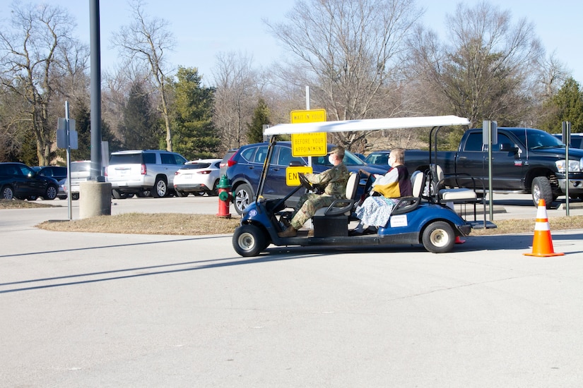 A Kentucky National Guard Soldier transports a Kentucky resident while supporting the Kentucky Horse Park COVID-19 vaccine distribution site in Lexington, Ky., April 25. The KYNG partnered with Kroger, Kentucky Emergency Management, and other state agencies to support seven mass vaccination sites across the state.