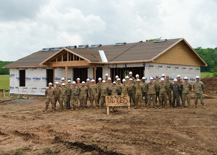 Alaska Air National Guardsmen with the 176th Civil Engineer Squadron stand alongside Brig. Gen. Anthony Stratton, 176th Wing commander, as they near the end of their participation in the Cherokee Veterans Housing Initiative in Tahlequah, Oklahoma, May 27, 2021. The initiative is a collaboration between the Department of Defense’s Innovative Readiness Training program and the Cherokee Nation that constructs new single-family homes and supporting infrastructure for eligible Cherokee Nation veterans and their families.  (U.S. Air Guard photo by Staff Sgt. Clay Cook)