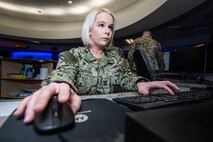 Navy member works on a computer.