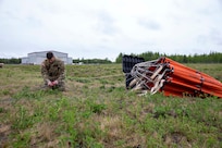 Staff Sgt. Kurt Miller, a crew chief with 1st Battalion, 207th Aviation Regiment, prepares a Bambi water bucket system to be attached to a UH-60 Black Hawk helicopter for the unit’s Red Card certification on Joint Base Elmendorf-Richardson, June 9, 2021. Red Card certification, also known as the Incident Qualification Card, is an accepted interagency certification that a person is qualified in order to accomplish the required mission when arriving on an incident. For 1-207th AVN pilots, this certification means proficiency in water bucket drops to assist with wildfire emergencies within the state. (U.S. Army National Guard photo by Spc. Grace Nechanicky)