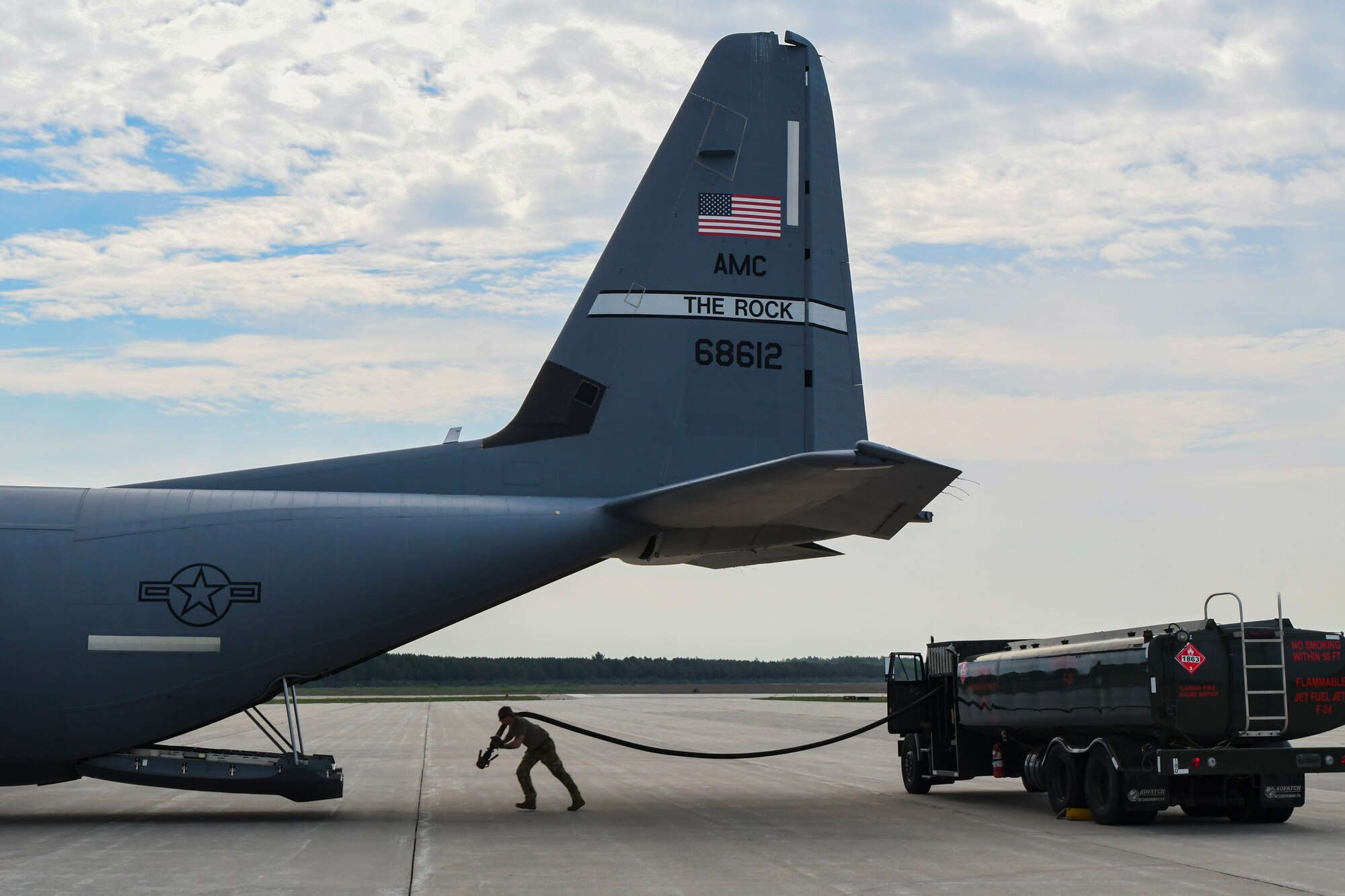 An Airman from the 19th Logistics Readiness Squadron pulls a hose from a fuel truck