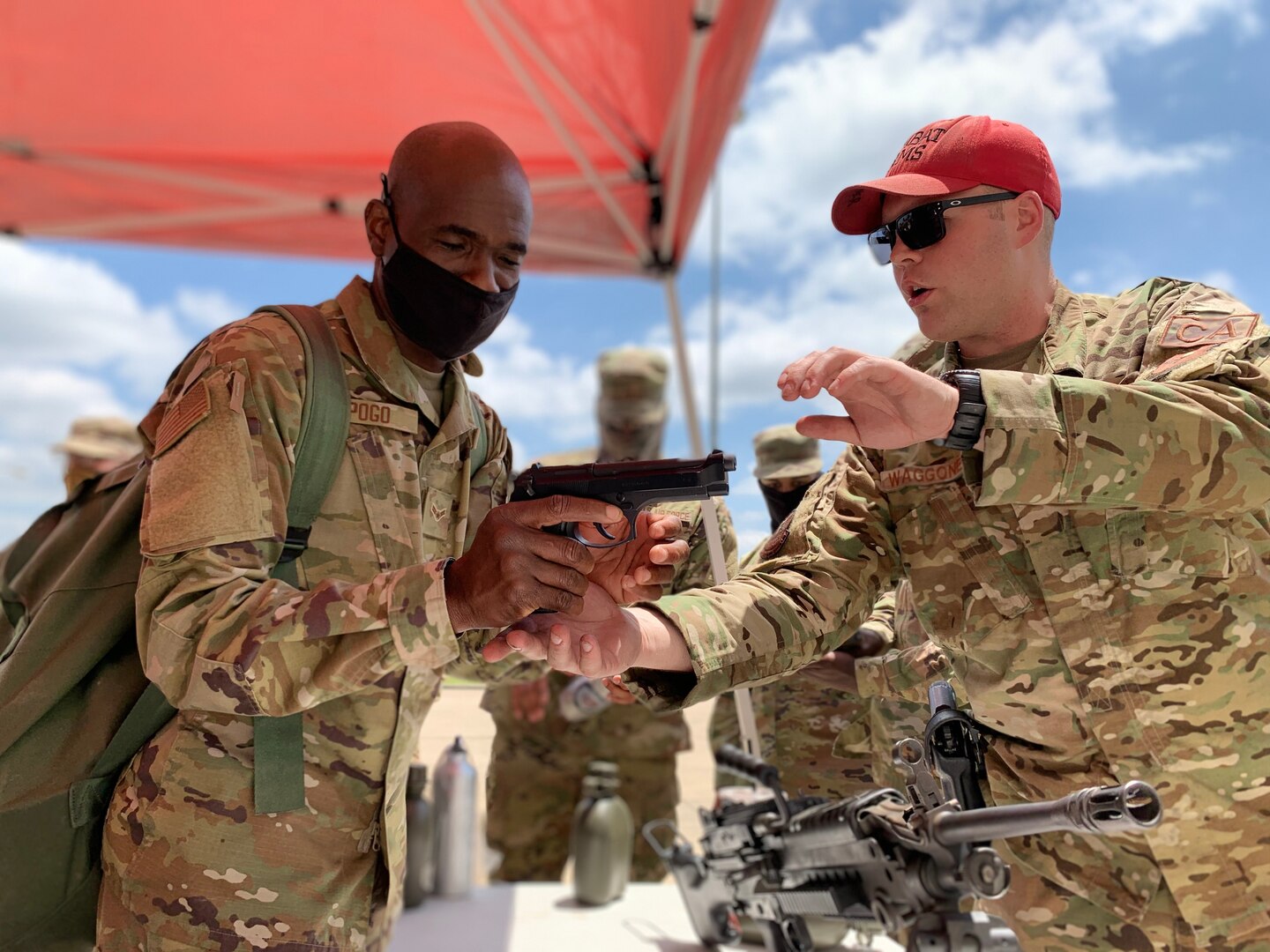 CATM instructor shows an Airman the workings of a handgun.