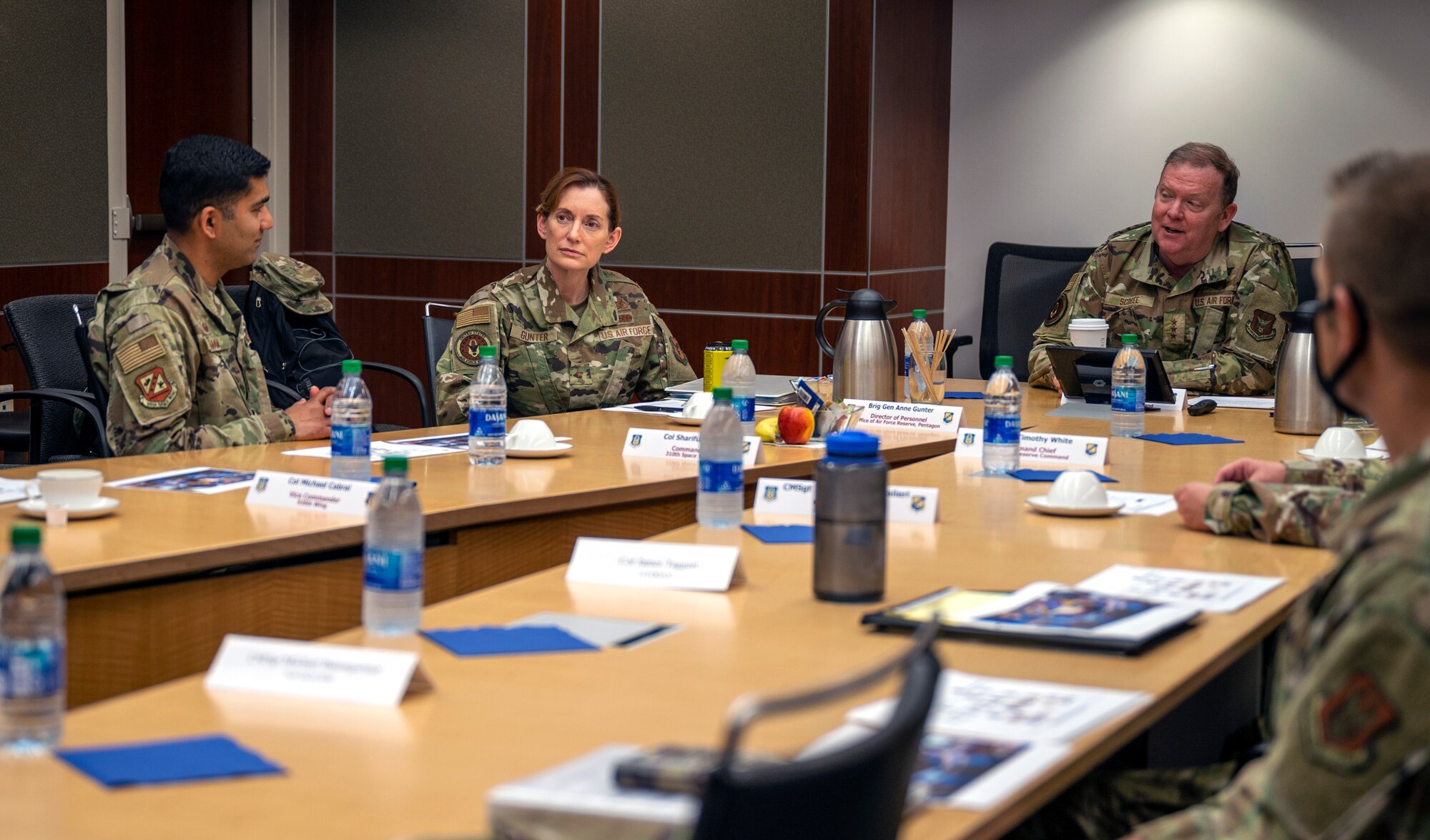 A photo of people sitting around a table speaking.