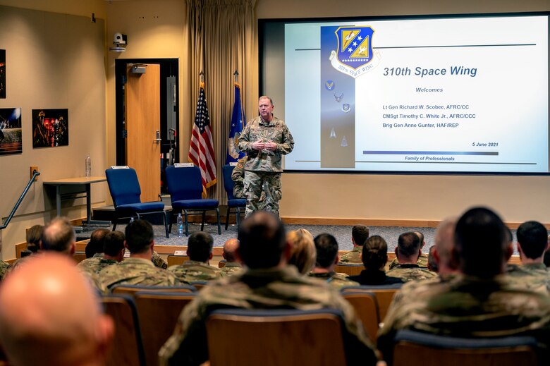 Photo of a man standing on a stage in front of an audience.
