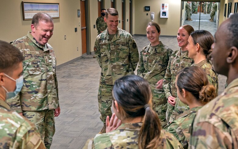 A photo of people standing in a hallway laughing.